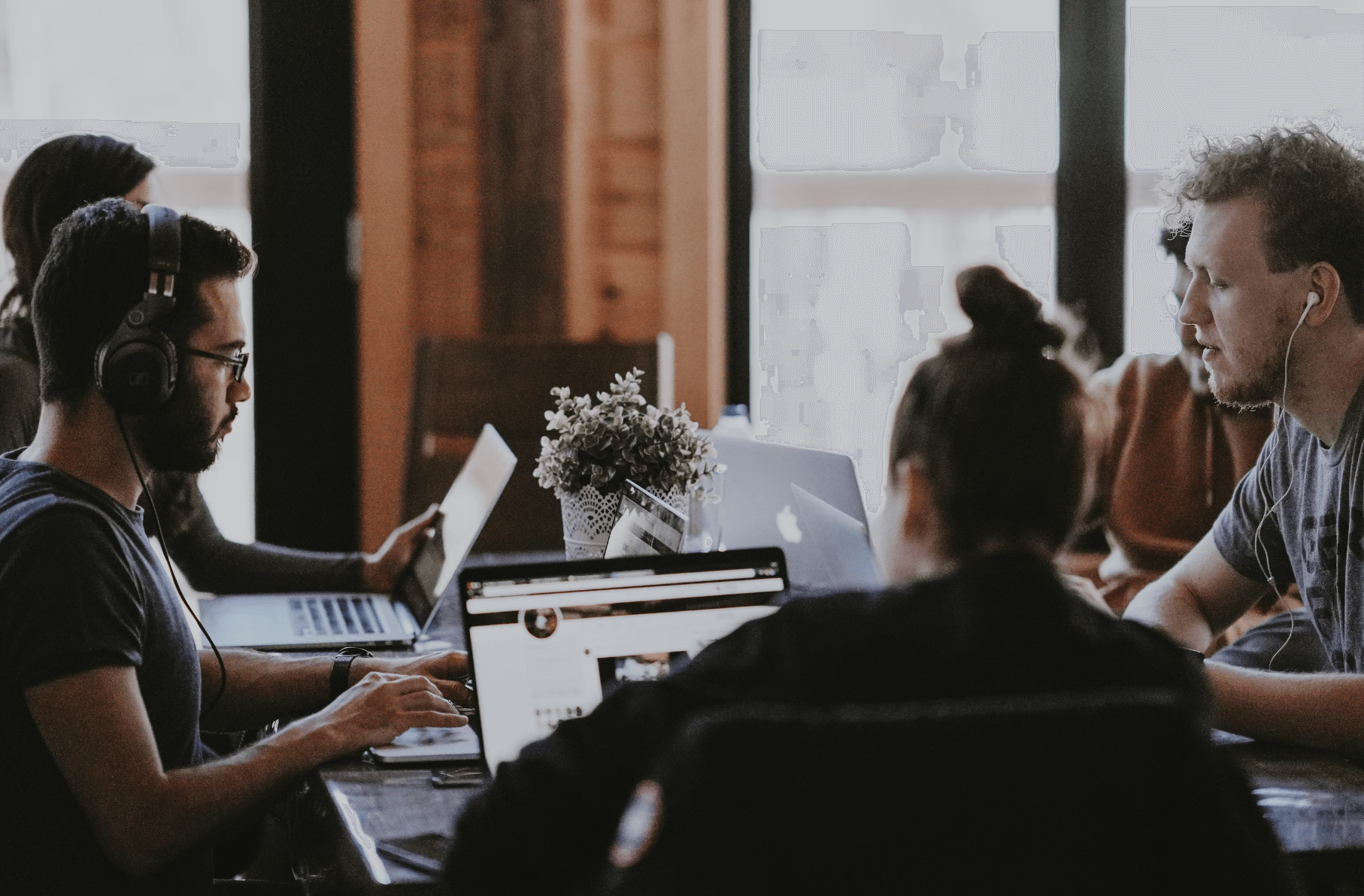 Group of people working on laptops on shared working space