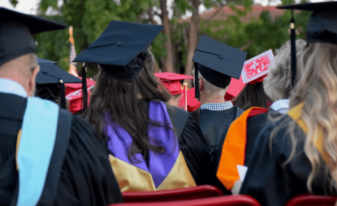 Accountancy opportunities for graduates. Shot from behind of group of people in mortarboards ready to graduate