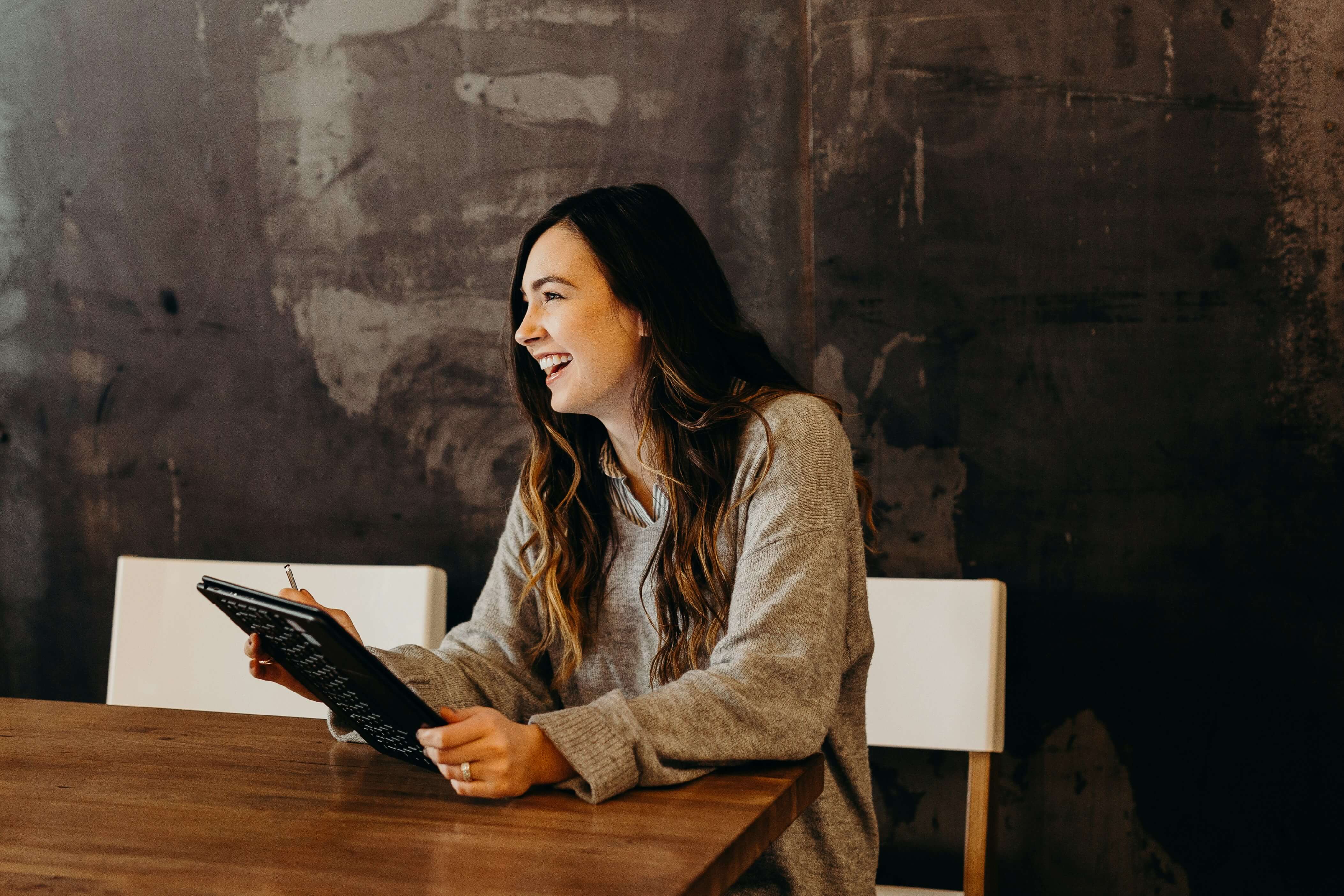 Bevan Buckland Accountants. Smiling woman holding iPad in shirt and jumper