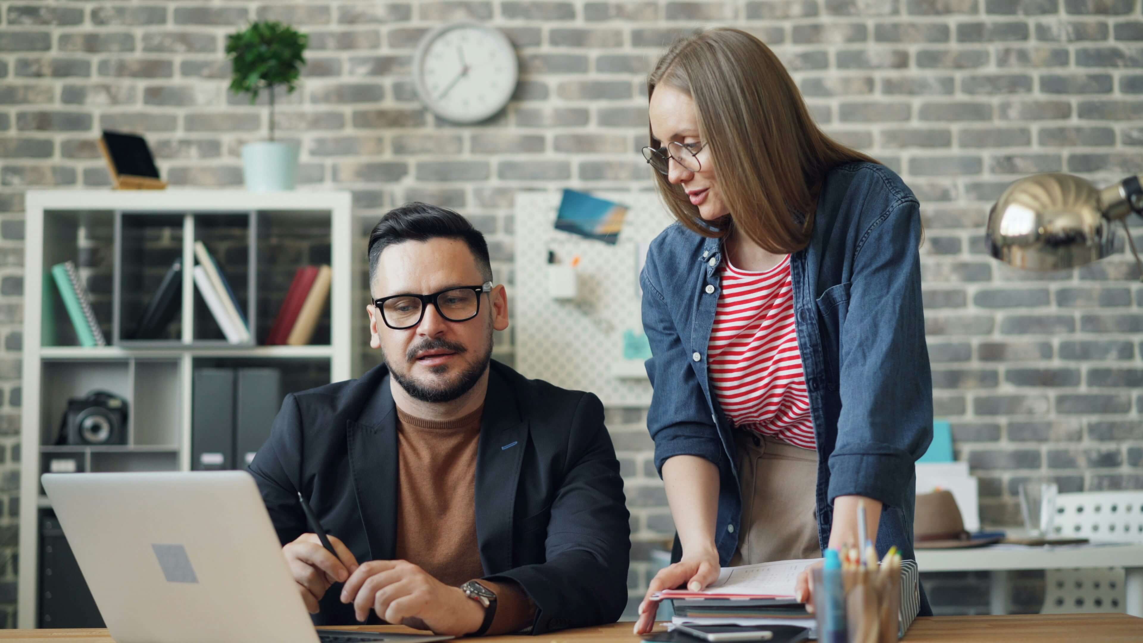 Man and woman looking at laptop in relaxed office setting